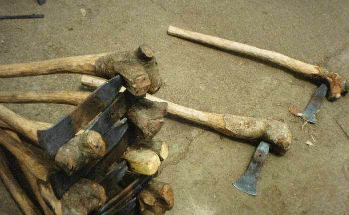 photo of axes with rough wooden handles 