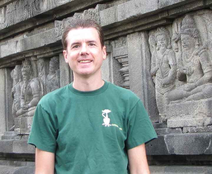photo of John Hunter in front of reliefs on Prambanan Temple